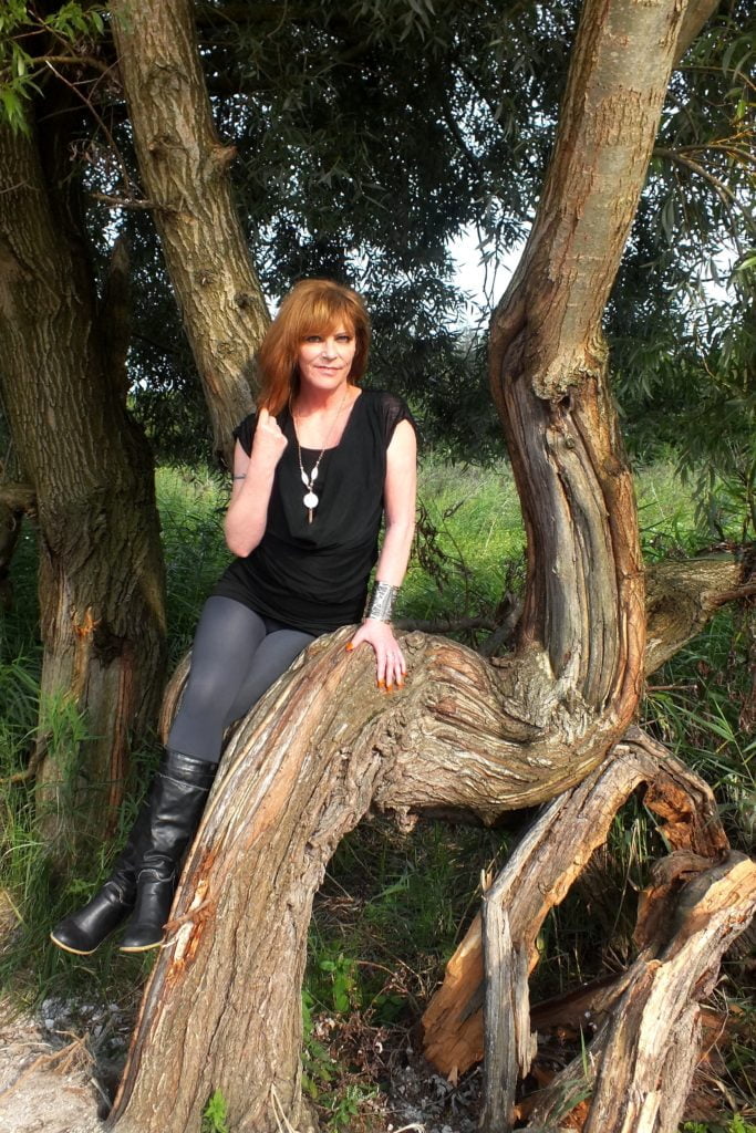 Model Monique, zittend op een boom in het natuurgebied van de Oostvaarders Plassen.